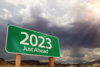2023 green road sign over dramatic clouds and sky