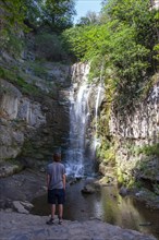 Junger Mann vor den Sulphur Wasserfall bei den Schwefelbaeder in Abanotubani