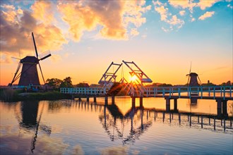 Netherlands rural landscape with windmills and bridge at famous tourist site Kinderdijk in Holland on sunset with dramatic sky