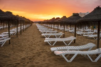 Beautiful colorful sunset over sun beds and umbrellas in Vilamoura