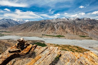 View of Spiti valley and Spiti river in Himalayas with stone cairn