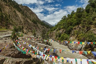 Lungta buddhist prayer flags in Lahaul valley over Chandra river in Himalayas