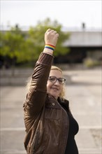 Young blonde woman showing lgbt wristband