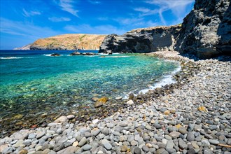 Papafragas beach with crystal clear turquoise water and tunnel rock formations in Milos island