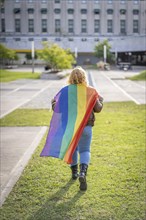 Woman from the back holding lgbt flag