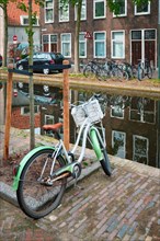 Netherlands popular means of transport bicycle parked near the canal in Delft street with old houses
