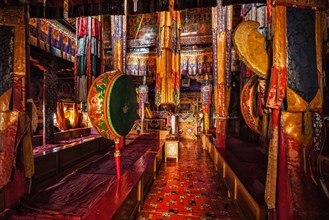 Inside Spituk Gompa Tibetan Buddhist monastery prayer hall with drums. Ladakh