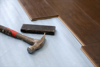Hammer and block with new laminate flooring abstract
