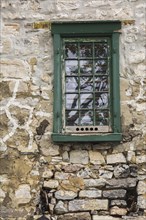 Green wooden window on the side wall of an old house ca. 1750