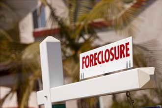Close-up foreclosure real estate sign in front of house