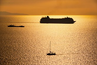 Cruise ship and yacht boat silhouettes in Aegean sea on sunset