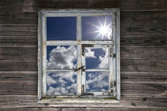 View through a rustic wooden window into the cloudy sky