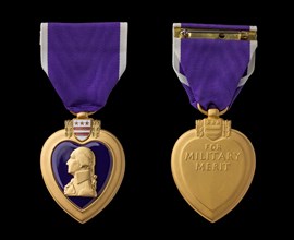 Front and back of purple heart military merit medal against black background