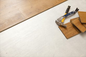 Worn hammer and pry bar with laminate flooring abstract with copy room