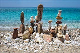 Concept of balance and harmony. Stones pebbles stacks on the beach coast of the blue sea in the nature. Meditative art of stone stacking