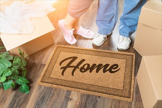 Man and woman unpacking near home welcome mat