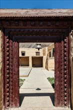 Gates with bell of Tabo monastery of Tibetan Buddhist Gelug sect. Monastery is built on high Himalaya plato in tradition of Tibetan Buddhism. Tabo village