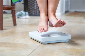 Woman floating slightly above surface of weight scale