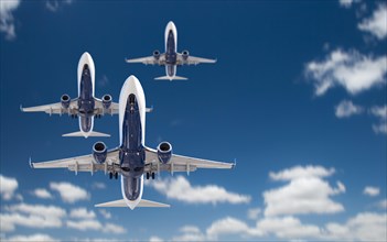 Bottom view of three passenger airplanes flying in the blue sky