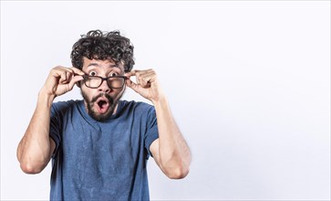 Surprised glasses man holding his glasses
