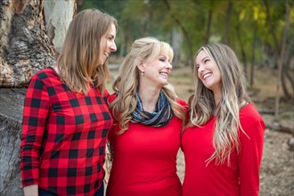 Beautiful mother and young adult daughters portrait outdoors