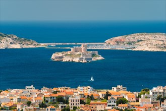 View of Marseille town and Chateau d'If castle famous historical fortress and prison on island in Marseille bay with yacht in sea
