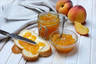Peach jam in a glass bowl with spoon