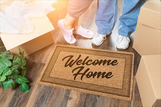 Man and woman unpacking near welcome home welcome mat