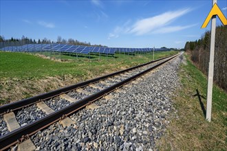 Solarmodule mit Sicherheitszaun neben Bahntrasse bei Kempten