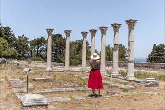 Young woman with dress in front of ruins with columns