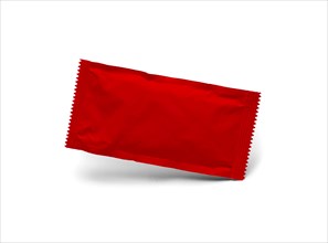 Blank red condiment packet floating isolated on white background