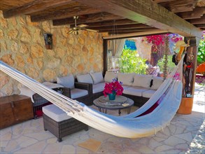 Covered wooden veranda with seating area and hammock