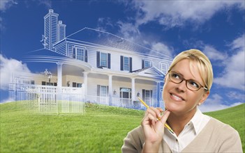Smiling woman holding pencil looking over to ghosted house drawing