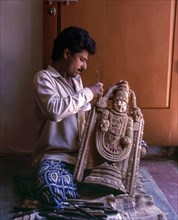 A craft man with his sandalwood Balaji or Vishnu in Mysuru or Mysore