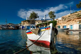 Fishing boat in crystal clear water in the harbor of Greek fishing village Mandrakia