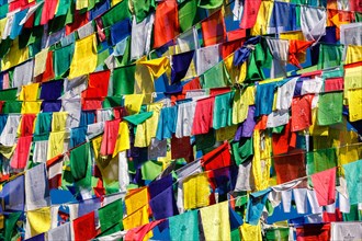 Buddhist prayer flags lungta with Om Mani Padme Hum Buddhist mantra prayer meaning Praise to the Jewel in the Lotus on kora around Tsuglagkhang complex. McLeod Ganj
