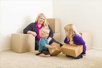 Happy young family in empty room with moving boxes