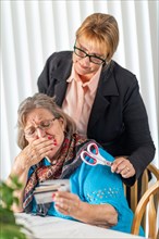 Financial consultant handing scissors to senior lady holding credit cards