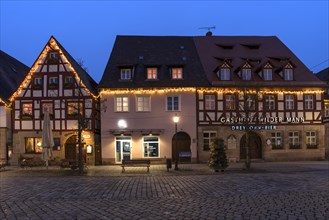 Historic half-timbered houses with Christmas lighting on the market square in the evening