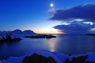 Full moon illuminates winter landscape and view over the fjord