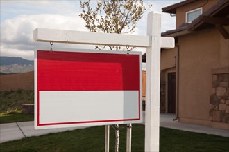 Blank red real estate sign in front of house ready for your own copy