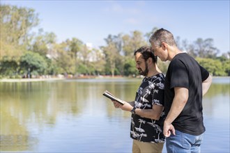 Couple of mature men reading in a lake