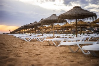 Beautiful colorful sunset over sun beds and umbrellas in Vilamoura