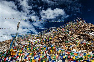 Tibetan prayer flags of Buddhism with Buddhist mantra on it on top of Himalayan pass Khardung La