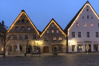 Historic gabled houses with Christmas lighting on the market square in the evening