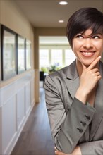 Attractive curious mixed-race woman inside hallway of new house