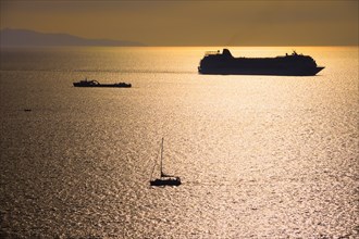 Cruise ship and yacht boat silhouettes in Aegean sea on sunset