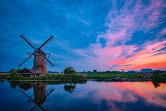 Netherlands rural landscape with windmills at famous tourist site Kinderdijk in Holland in dusk with dramatic sky