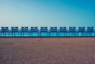 Famous blue chairs bench on beach in the morning