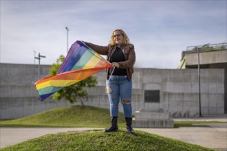 Young blonde woman holding lgbt flag. Concept of freedom and tolerance